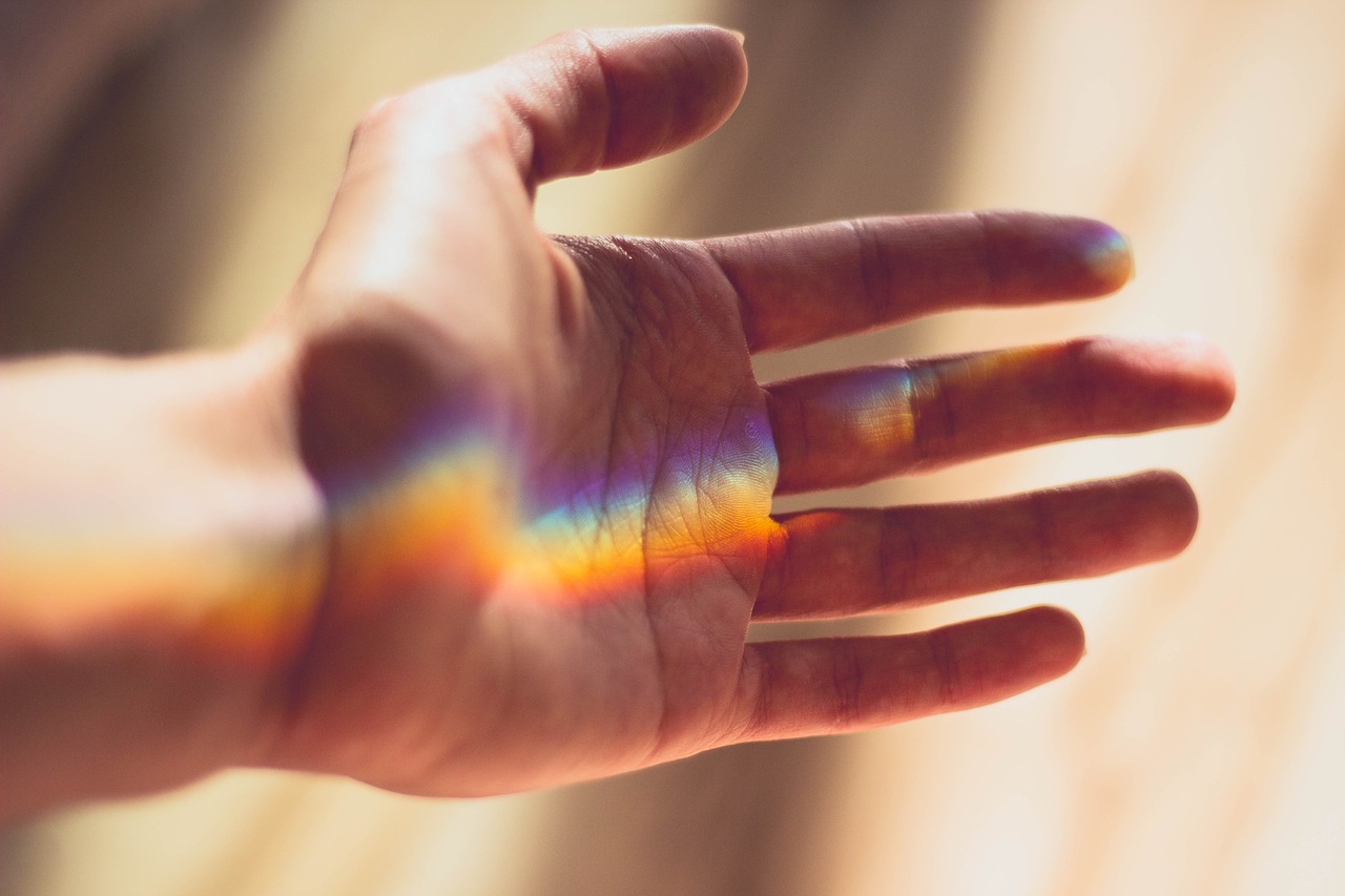 hand-2326058_1280 Seitlich geöffnete Hand mit Regenbogenstrahlen, die darauf scheinen
