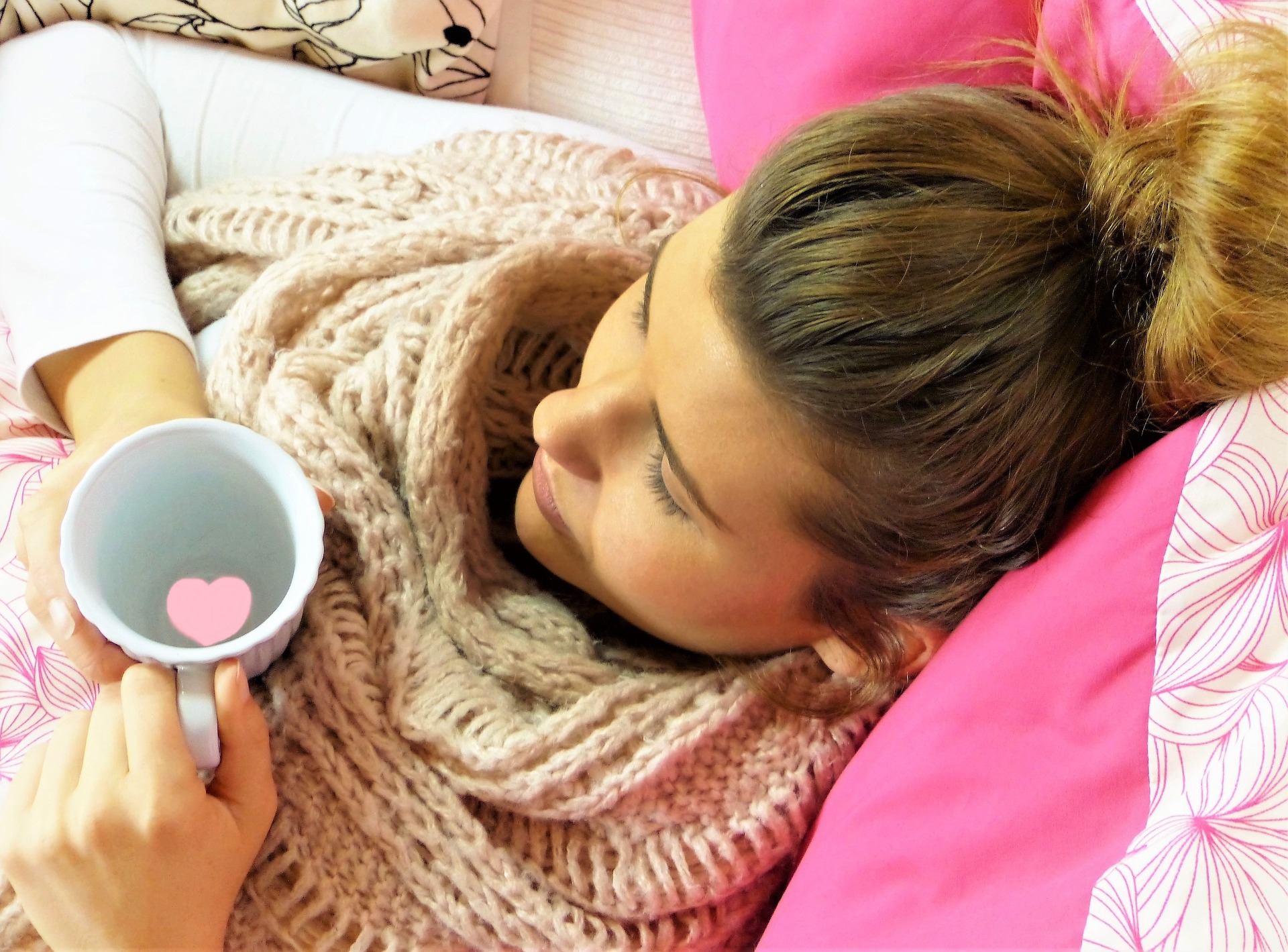 young-woman-2239269_1920 Frau von oben gesehen liegt auf ihrem Bett, mit Schal und Teetasse in der Hand