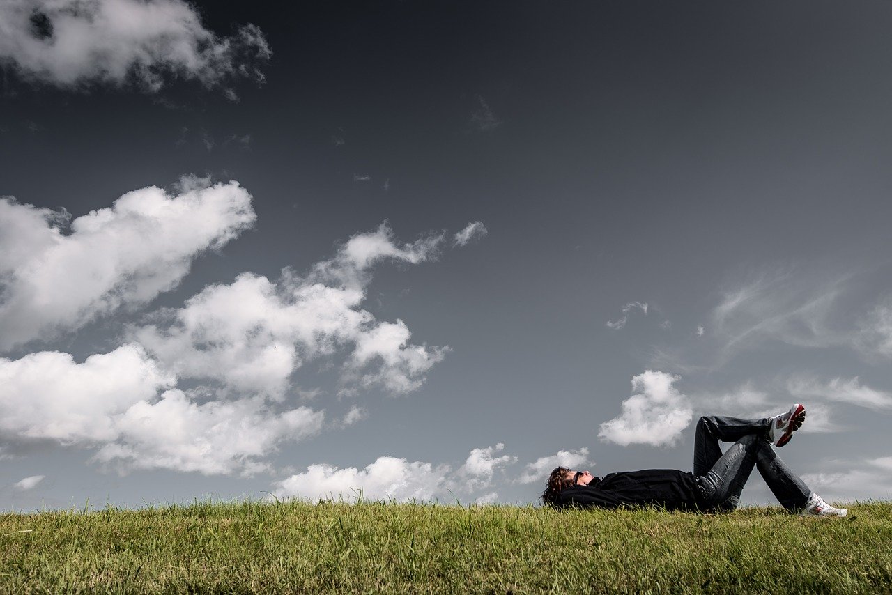 man-1867800_1280 Mann liegt im Gras und schaut in die Wolken als Sinnbild für eigene Träume und die Löffelliste
