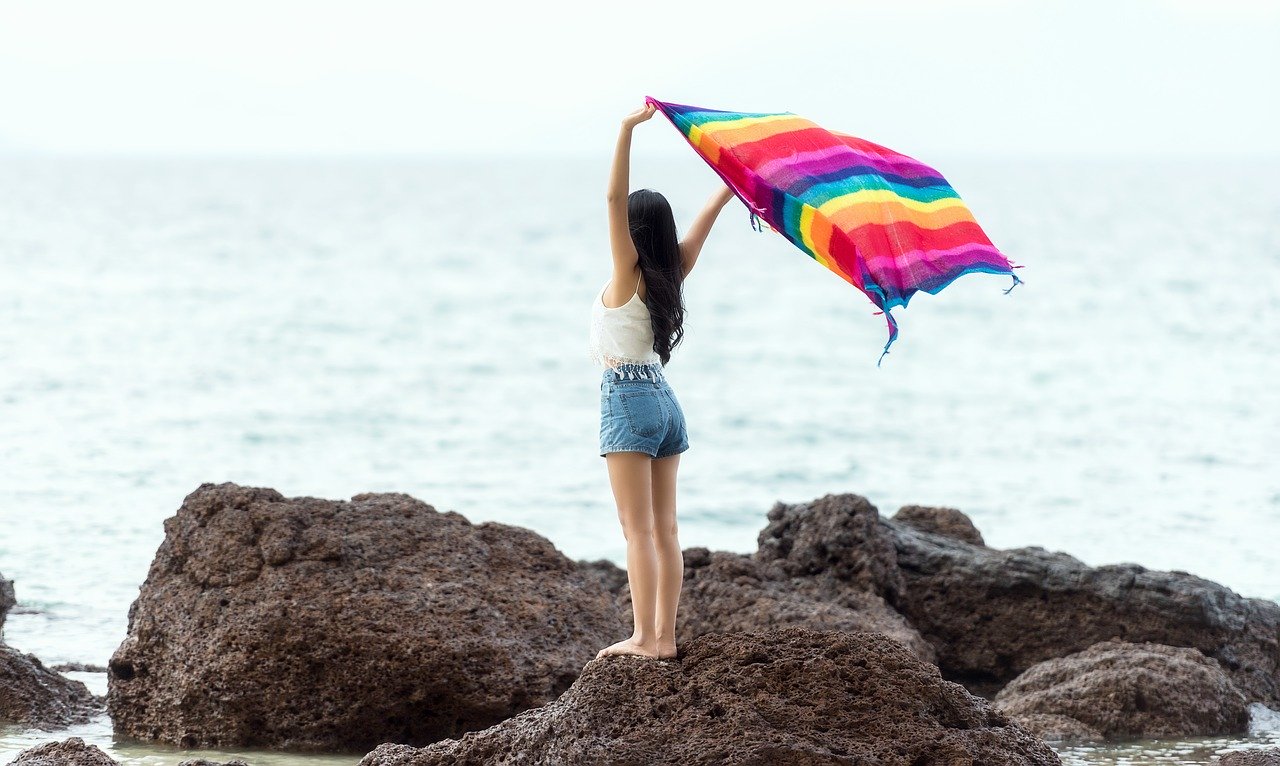 bali-1807464_1280 Junge Frau hält auf einem Felsen ein Handtuch in die Luft als Sinnbild für die Gedanken in uns