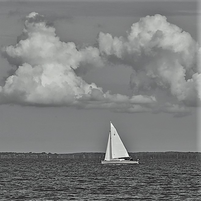 Segelboot mit Wolken über sich ls Sinnbild für einen Motivationsspruch