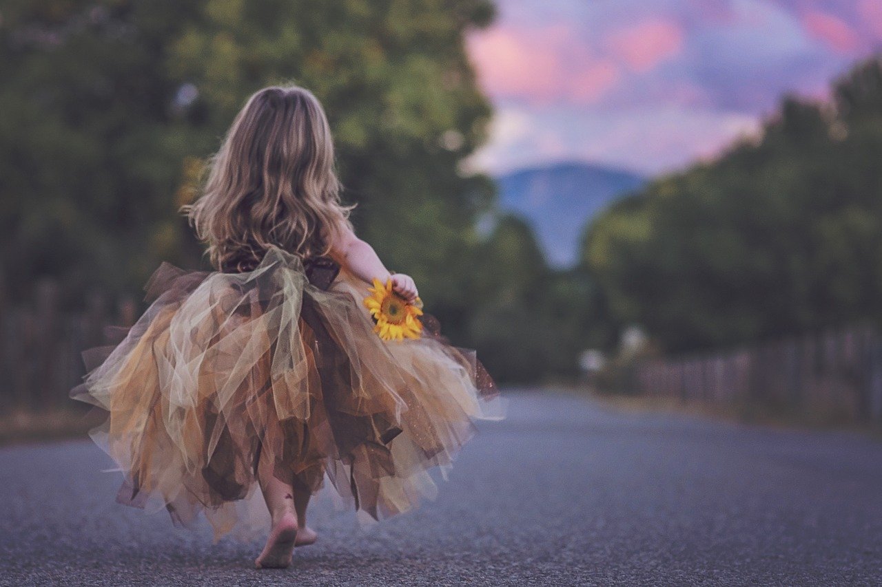 childhood-2483894_1280 Kleines Mädchen von hinten zu sehen mit einer Blume in der Hand als Sinnbild für Selbstvertrauen
