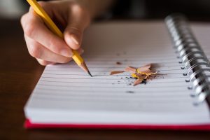 Notizblock und Hand mit Bleistift die schreibt