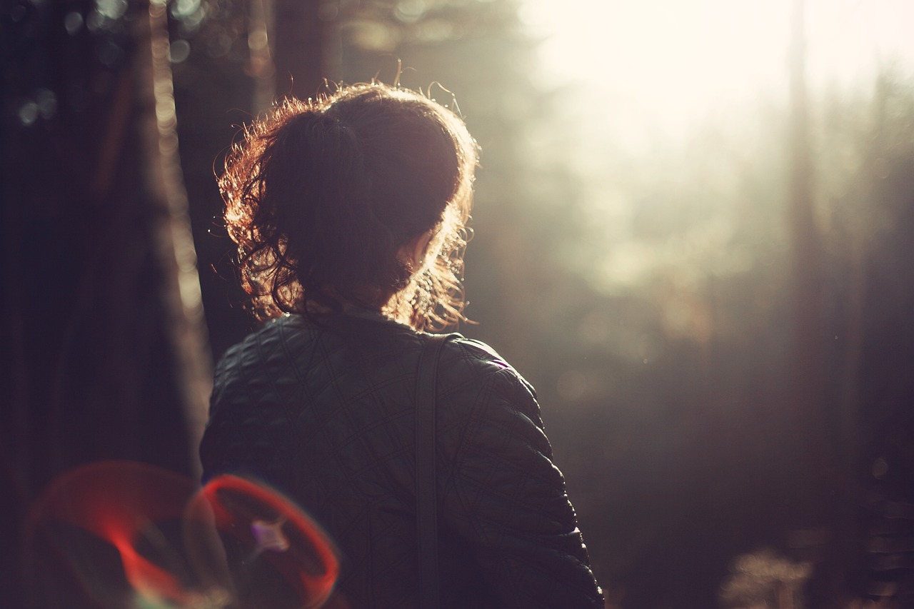 peace-of-mind-349815_1280 Frau im Wald von hinten sichtbar im sanften Licht
