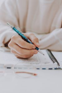 Hand mit einem Stift, die schreibt als Sinnbild für Schreiben als Selbstcoaching