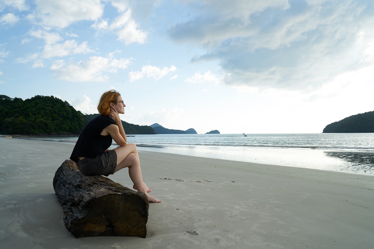 So findest du deine Berufung Frau sitzt auf einem Baumstamm am Meer